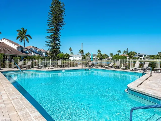 Community pool with a patio area and a residential view