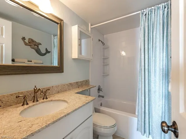 Bathroom featuring shower / bath combo with shower curtain and vanity