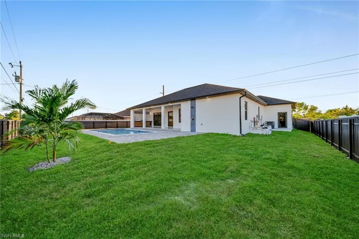 Rear view of house with a patio, a fenced backyard, and stucco siding
