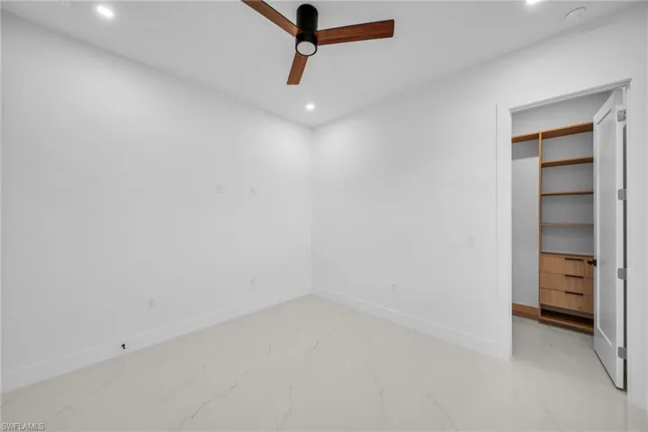 Unfurnished bedroom featuring a ceiling fan, recessed lighting, and marble finish floors