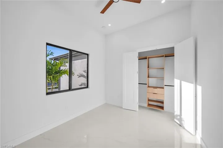 Unfurnished bedroom featuring light marble finish floors, ceiling fan, recessed lighting, and a closet