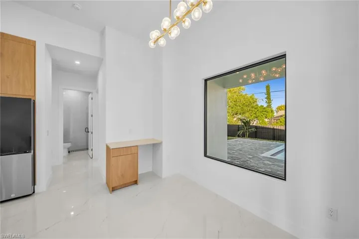 Unfurnished dining area with light marble finish flooring and a chandelier