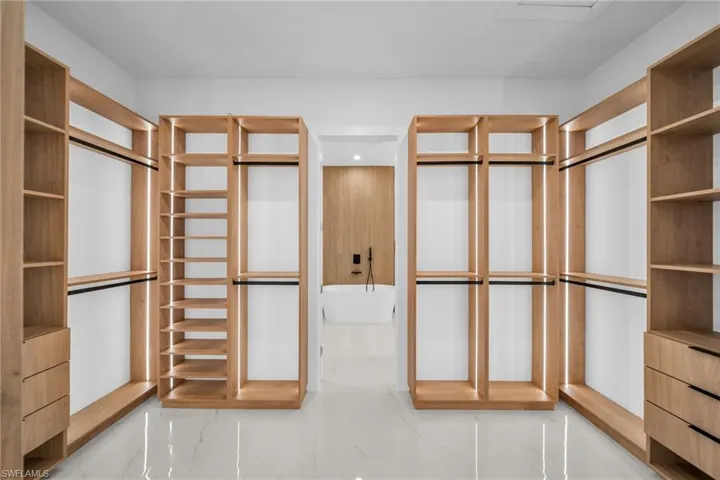 Walk in closet featuring marble finish flooring