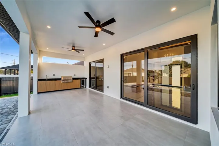 View of patio featuring exterior kitchen, beverage cooler, and ceiling fan
