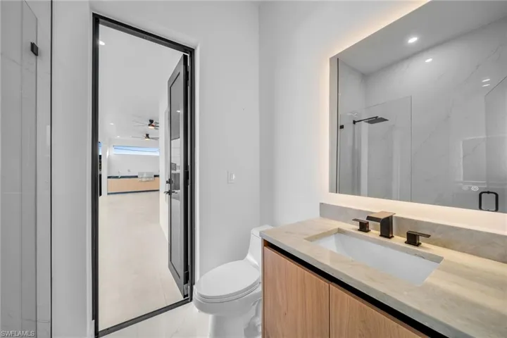 Bathroom featuring a marble finish shower, vanity, recessed lighting, and a ceiling fan