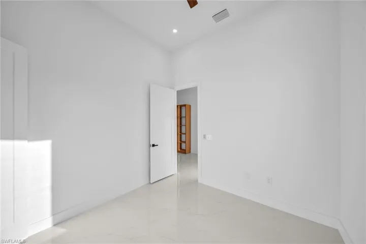 Unfurnished room with light marble finish floors and recessed lighting