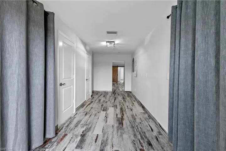 Corridor with hardwood / wood-style floors