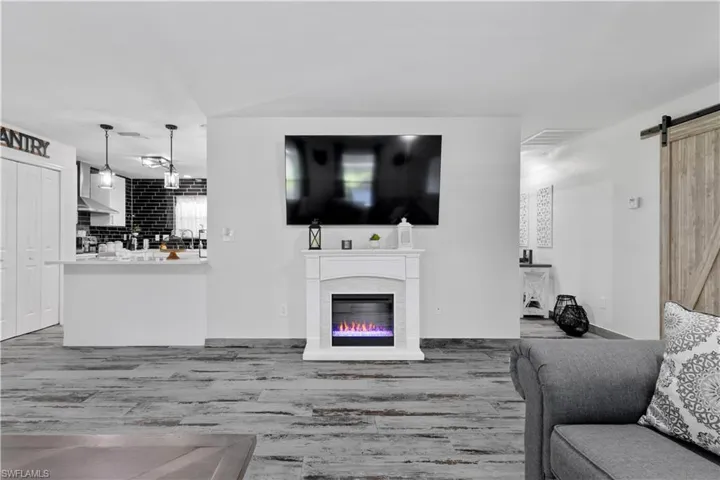 Living room with a barn door and hardwood / wood-style floors