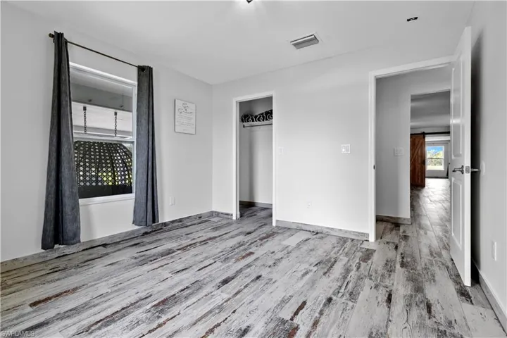 Unfurnished bedroom with wood-type flooring and a closet