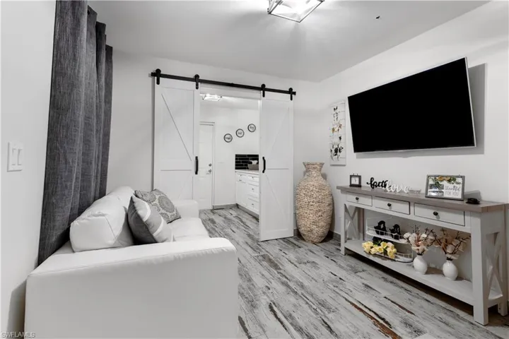 Living room with light hardwood / wood-style floors and a barn door