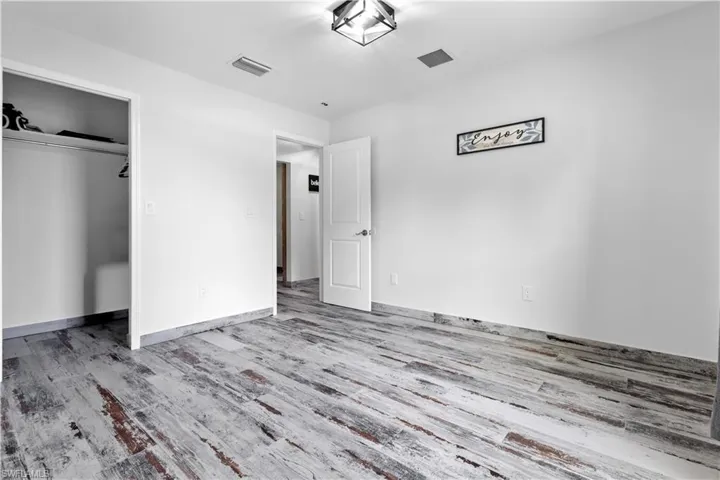 Unfurnished bedroom with hardwood / wood-style flooring and a closet