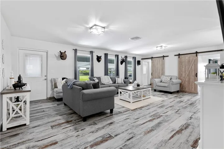 Living room with wood-type flooring and a barn door
