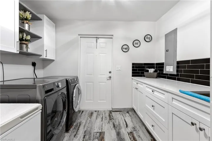 Washroom with cabinets, light hardwood / wood-style flooring, and independent washer and dryer