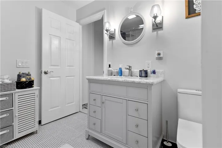 Bathroom with vanity, toilet, and tile patterned flooring