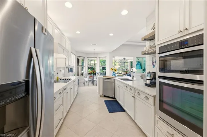 Kitchen with appliances with stainless steel finishes, recessed lighting, a peninsula, white cabinetry, and backsplash