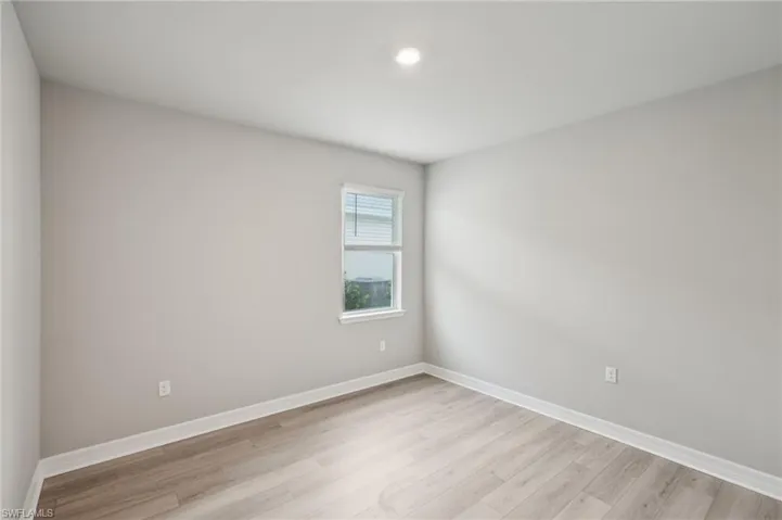 Spare room with light wood finished floors, baseboards, and recessed lighting