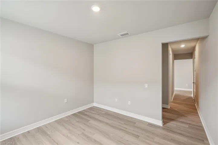 Unfurnished room with light wood-type flooring, baseboards, and recessed lighting