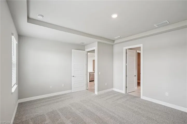 Unfurnished bedroom with baseboards, light carpet, and recessed lighting
