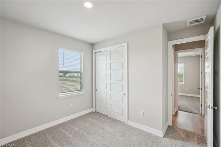 Unfurnished bedroom with carpet, a closet, baseboards, and recessed lighting