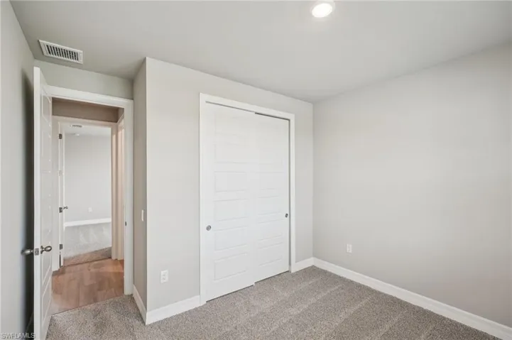 Unfurnished bedroom with carpet, baseboards, and a closet