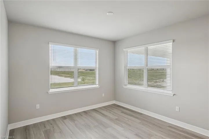 Unfurnished room with light wood-type flooring and baseboards