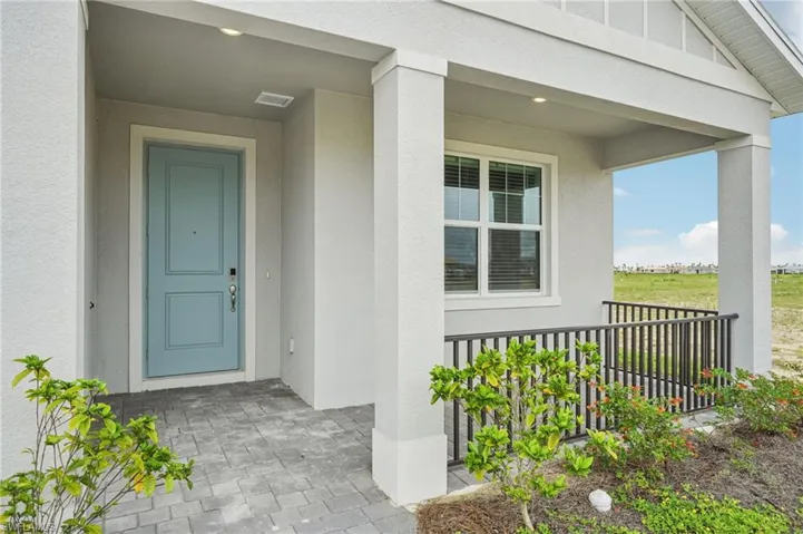 View of exterior entry featuring stucco siding and covered porch