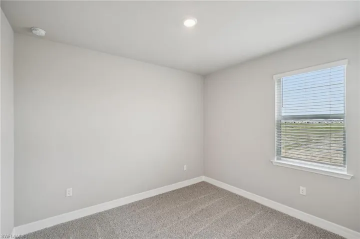 Empty room featuring carpet floors, baseboards, and recessed lighting