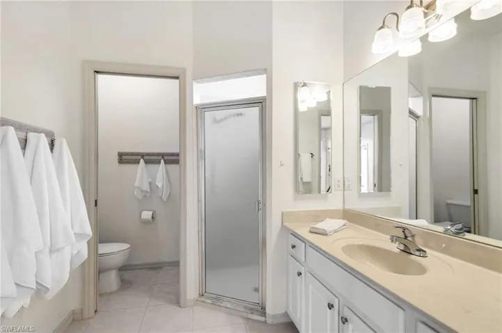 Bathroom with vanity, a stall shower, and tile patterned flooring