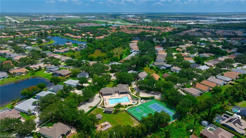 Aerial view of property and surrounding area featuring nearby suburban area and a large body of water