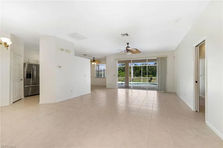 Empty room featuring a ceiling fan and light tile