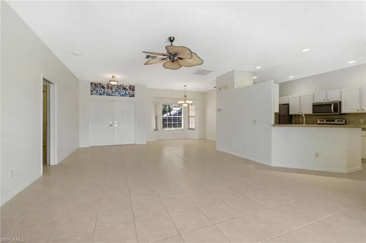 Unfurnished living room featuring a ceiling fan tile patterned flooring, ceiling fan, and recessed lighting