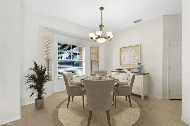 Dining area with light tile patterned floors and a chandelier