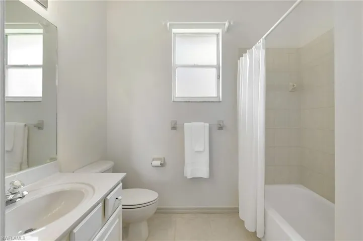 Full bathroom with vanity, tile patterned floors, and shower / tub combo