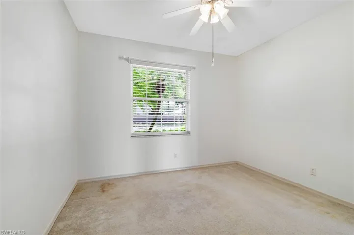Carpeted Guest bedroom featuring a ceiling fan and baseboards