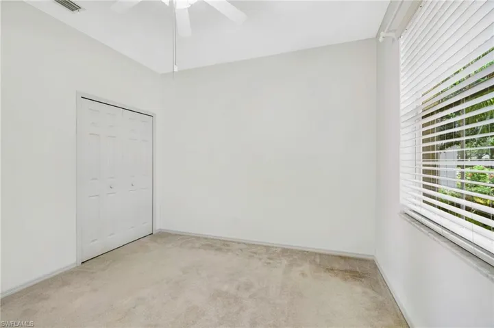 Guest bedroom with healthy amount of natural light, light carpet, and ceiling fan