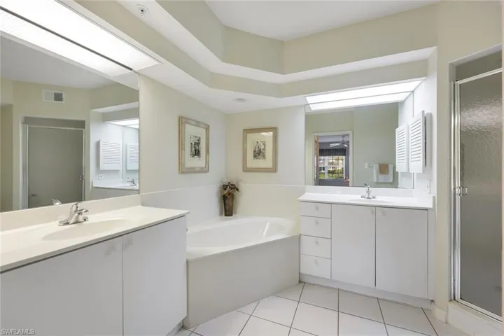 Bathroom with tile patterned flooring, vanity, and shower with separate bathtub