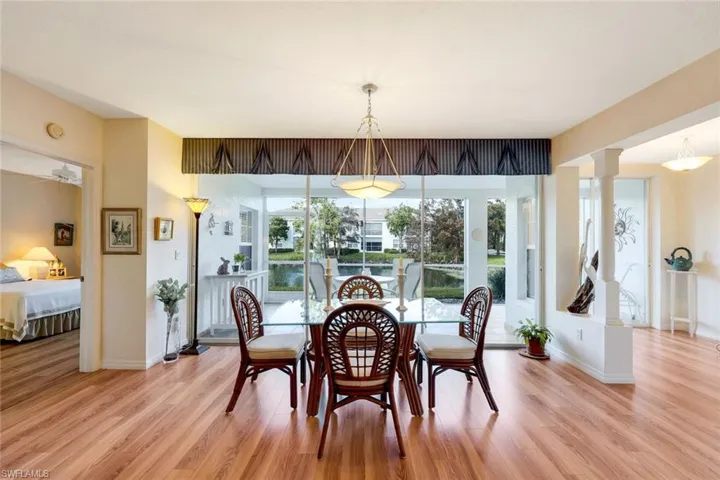 Dining area with decorative columns, ceiling fan, and light hardwood / wood-style floors