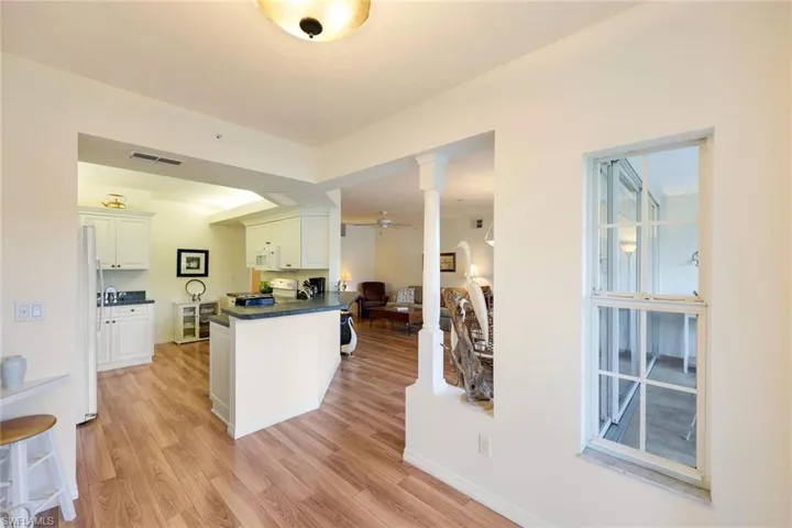Kitchen featuring white appliances, white cabinets, ceiling fan, light hardwood / wood-style floors, and kitchen peninsula