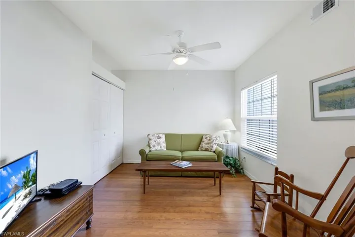 Living area with ceiling fan and wood-type flooring
