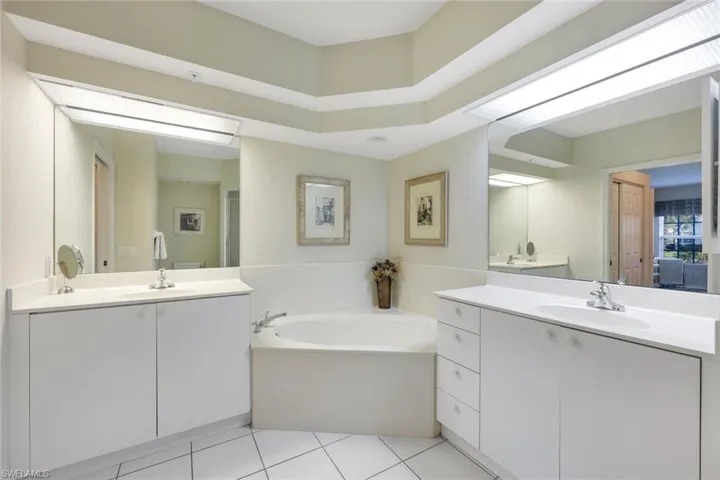 Bathroom with vanity, tile patterned floors, and a tub