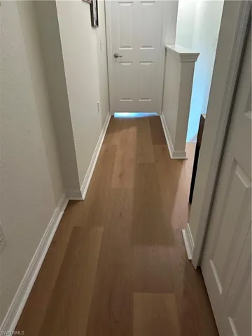 Hall featuring light wood-style floors and a textured wall