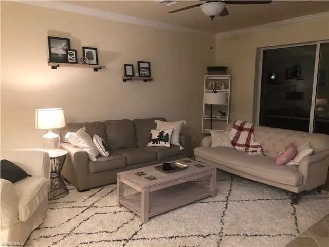 Living room featuring crown molding and a ceiling fan