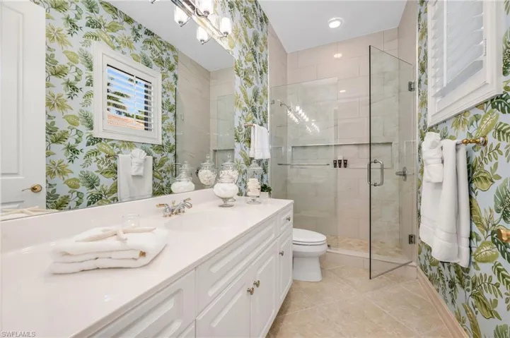 Guest Bath 2 has a large, updated shower with frameless shower doors and fabulous, fun wallpaper.