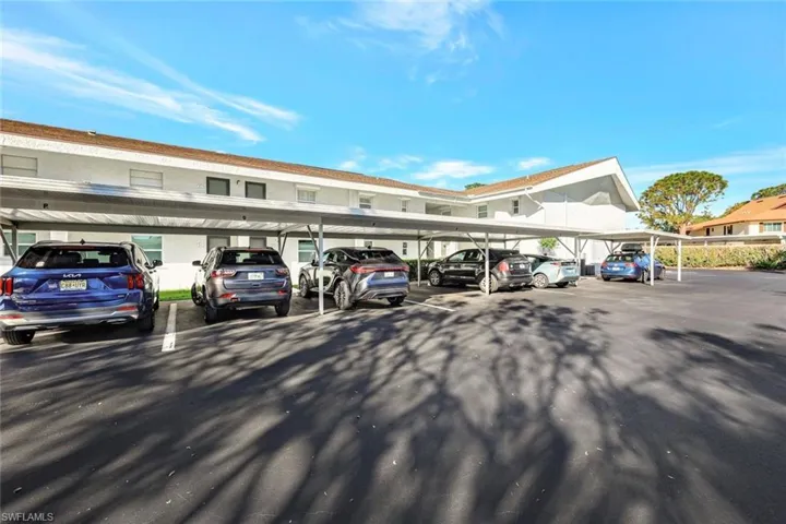 View of parking / parking lot with a carport