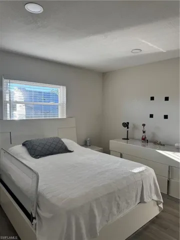 Bedroom featuring dark wood-type flooring, a textured ceiling, and recessed lighting