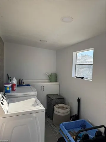 Laundry area with tile patterned flooring and washer and clothes dryer