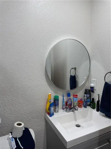 Bathroom featuring vanity and a textured wall