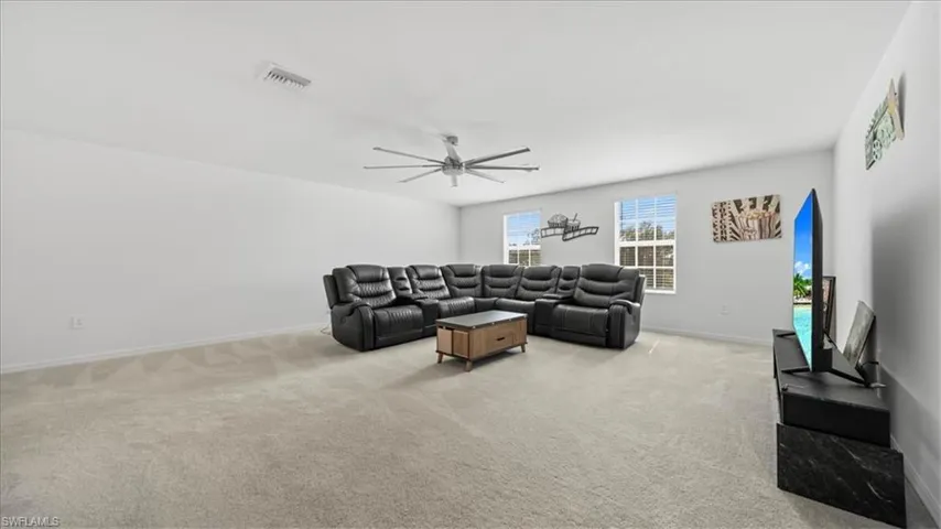 Living area with light carpet and ceiling fan