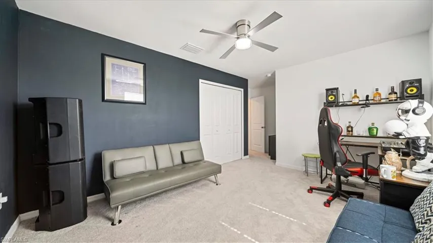 Home office with carpet and ceiling fan