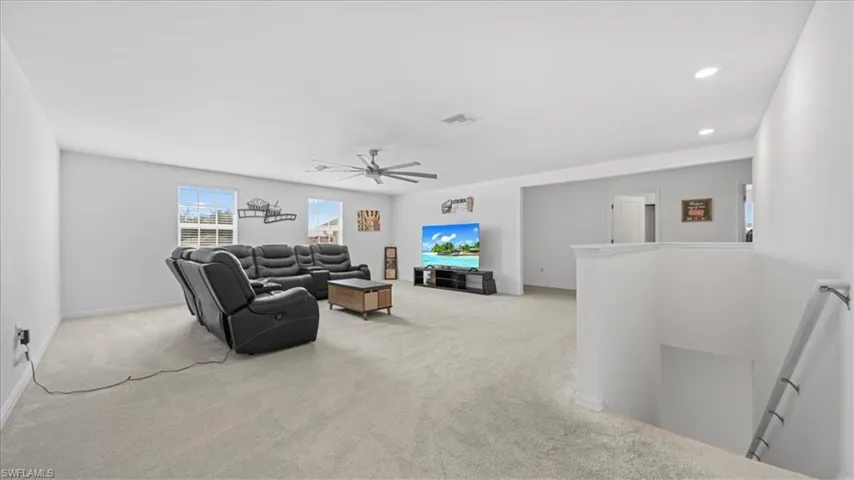 Living room with light carpet, ceiling fan, and recessed lighting